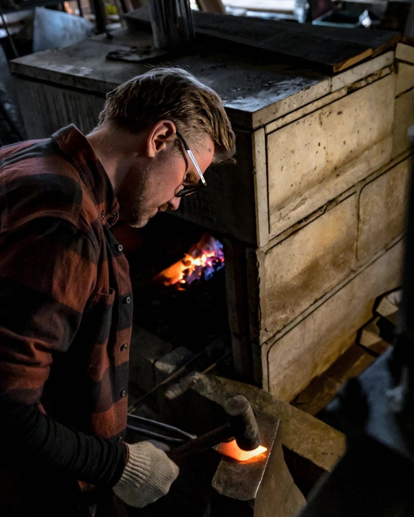 Fredrik Spåre hammering glowing steel by hand in the workshop